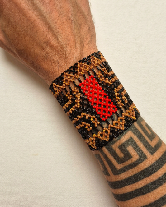 Pulseira de miçangas do povo Waura no pulso, com fundo off-white